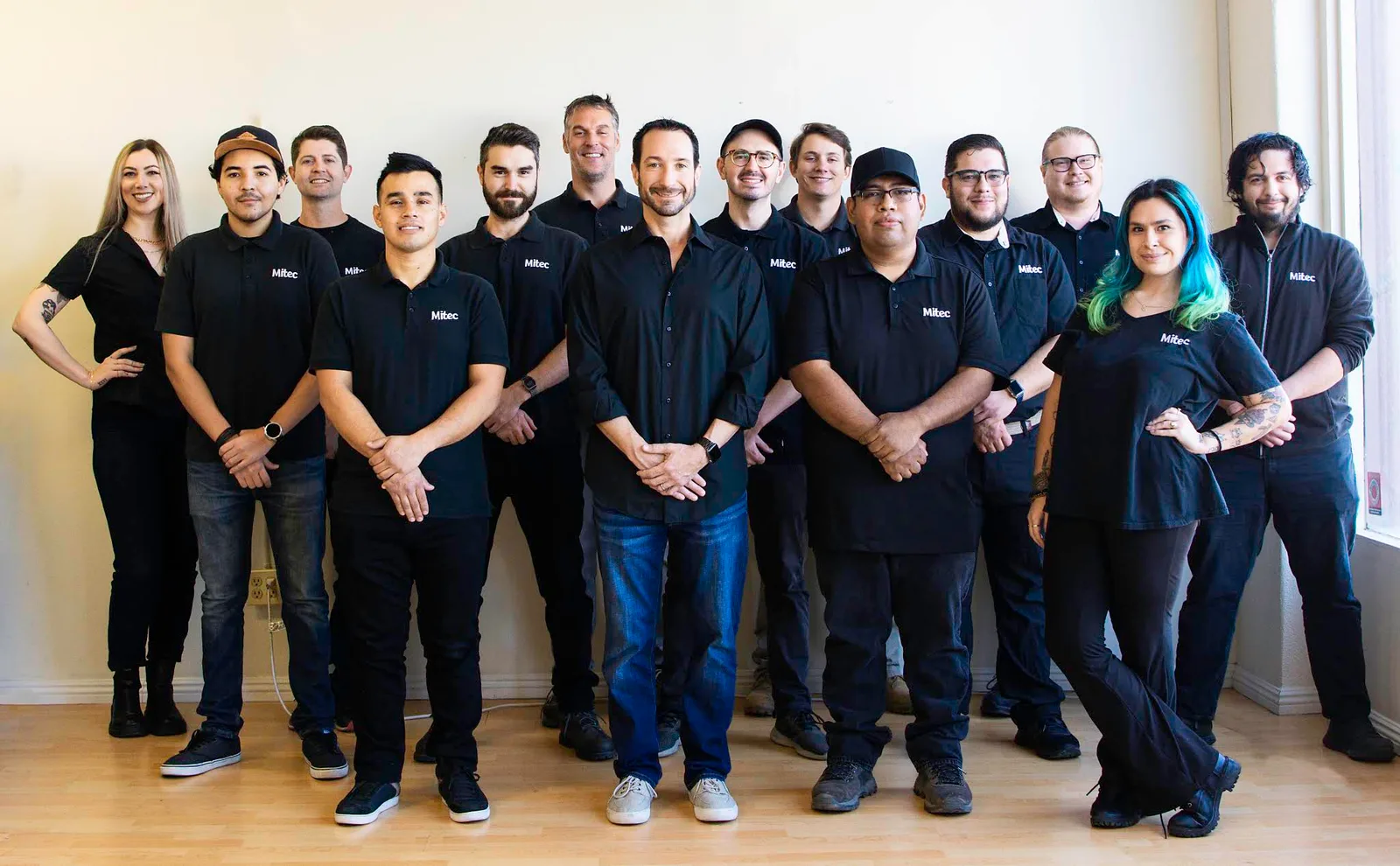 Mitec team members posing together in Mitec shirts